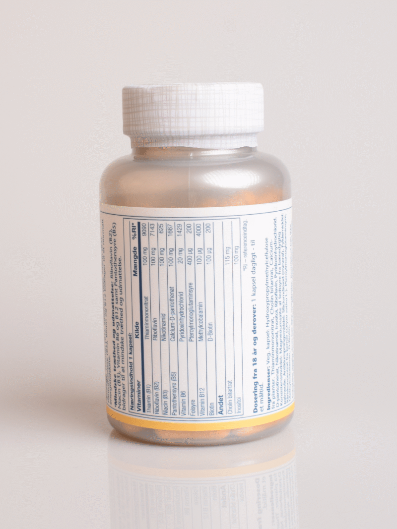 Flaske med vitamin B-kompleks kosttilskud, hvidt låg og næringstabel på etiketten