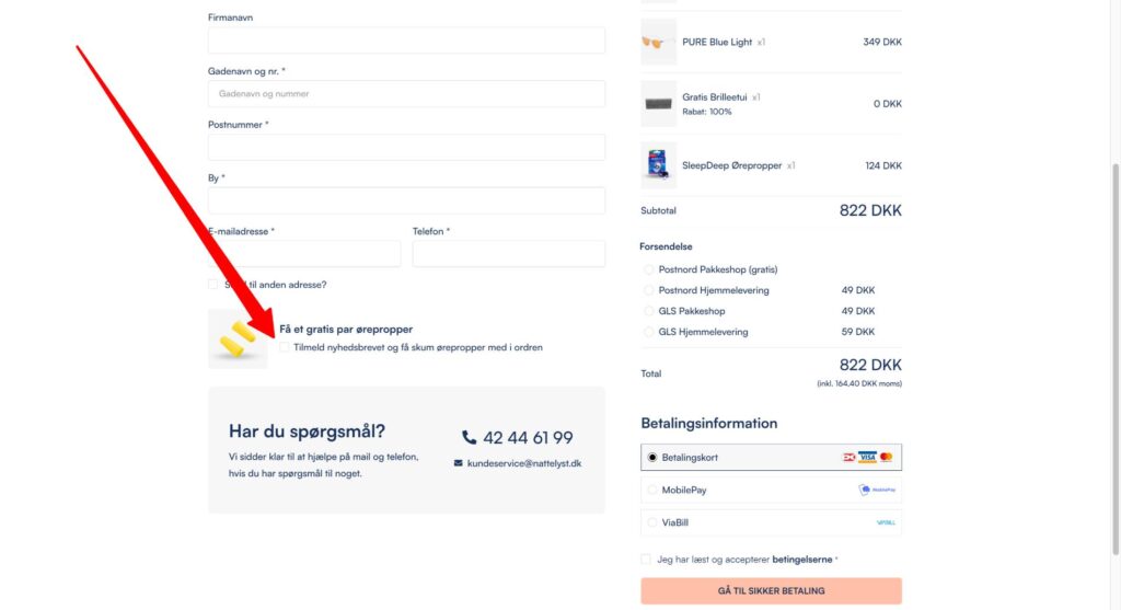 Checkout-side med rød pil, fremhæver afkrydsningsfelt for gratis par skumørepropper ved tilmelding