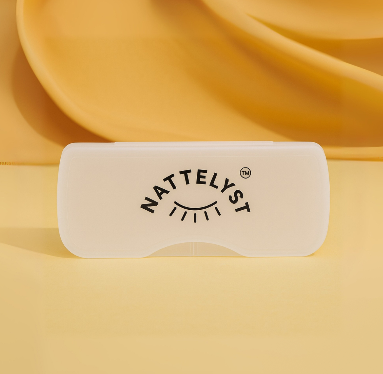 Gennemsigtigt hvidt etui med NATTELYST-logo på varm gul baggrund
