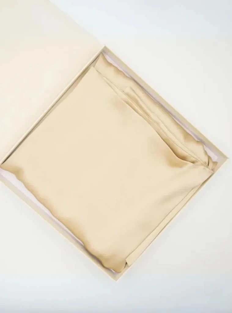 Beige silkeblød pudebetræk elegant foldet i hvid gaveæske